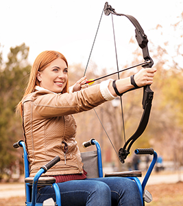 Une femme qui est un archer pratique dans un fauteuil roulant
