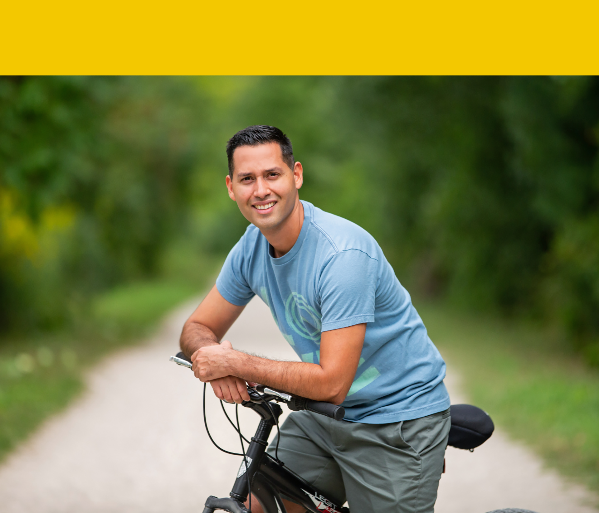 Jonathan Arevaln, survivant souriant d’un AVC, assis sur une bicyclette