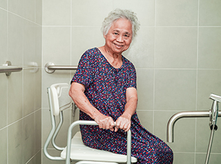 Smiling senior woman in modified bath/shower